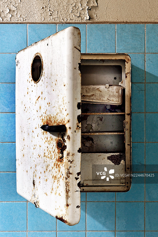 废弃建筑墙边的一个老式白色小柜子图片素材