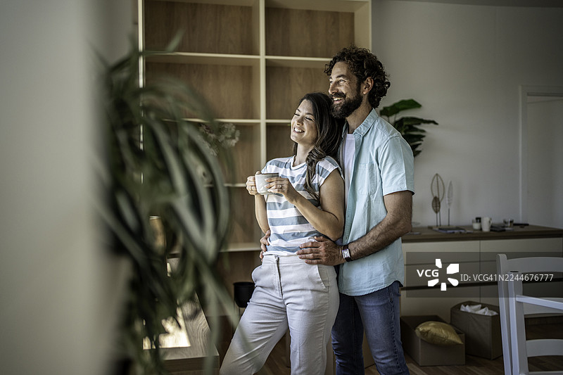 幸福的情侣在他们的新家憧憬着未来图片素材