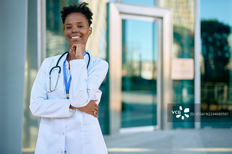 一位黑人医生自信地在办公楼外微笑图片素材