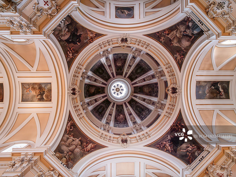 低角度拍摄的武装部队大教堂(Iglesia Catedral de las Fuerzas Armadas 或 Iglesia del Sacramento)穹顶,展示了描绘宗教场景和人物的天花板及壁画,位于西班牙马德里拉拉丁区。图片素材