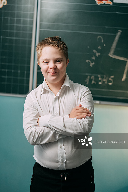 唐氏综合征的男生自信地站在教室里图片素材