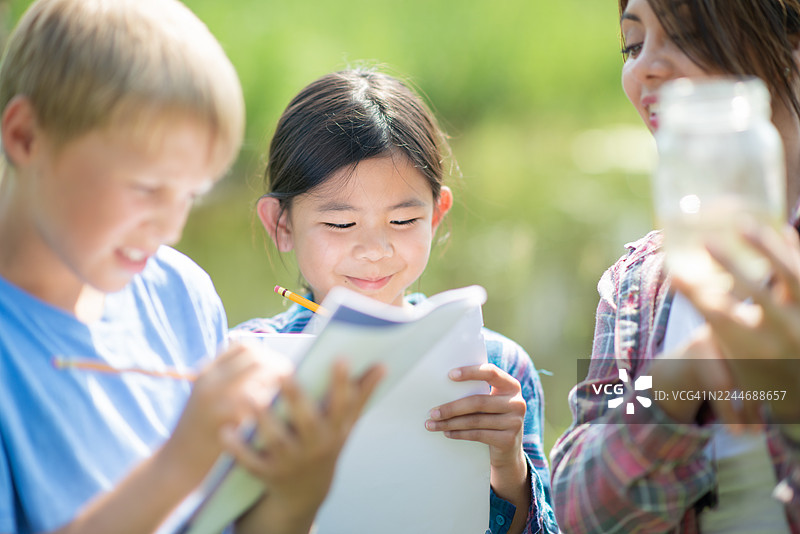 户外科学课上，快乐的孩子们和老师一起学习图片素材