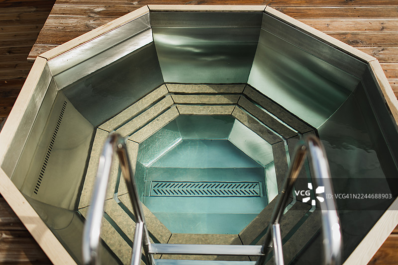 户外带木质座椅的浴缸，背景留有复制空间。现代化的浴室设备。图片素材