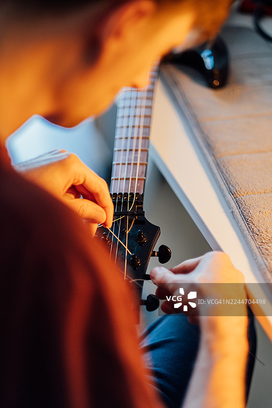一个人正在手动调音电吉他图片素材