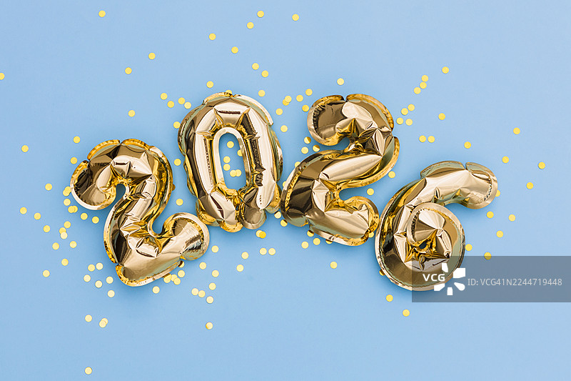 金色2026气球搭配蓝色背景上的纸屑图片素材