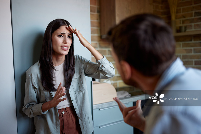 不高兴的女人在家和她的男朋友争吵。图片素材