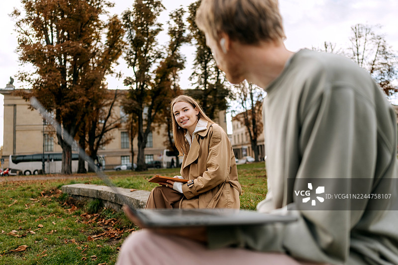 柏林老博物馆公园里，两个人正在用笔记本电脑和平板电脑工作图片素材