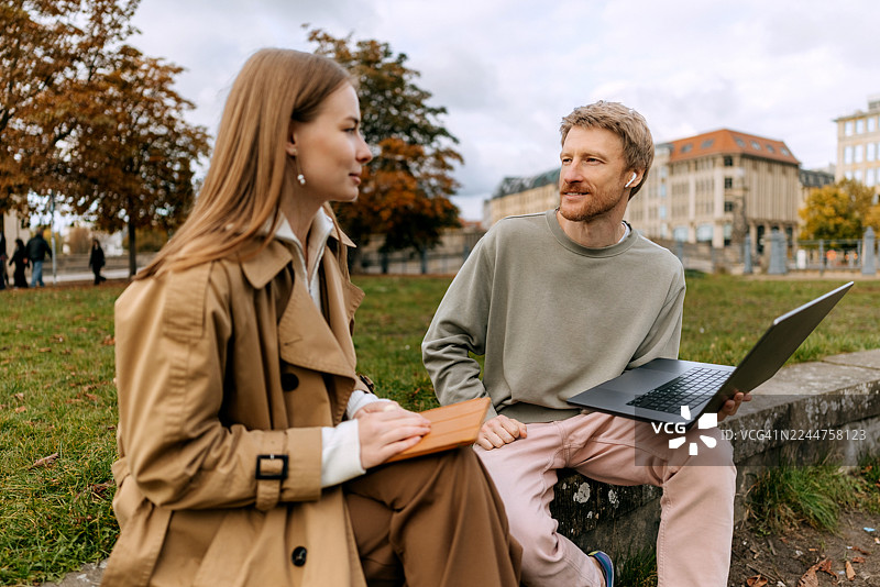 朋友们在柏林老博物馆附近放松，使用笔记本电脑和平板电脑图片素材