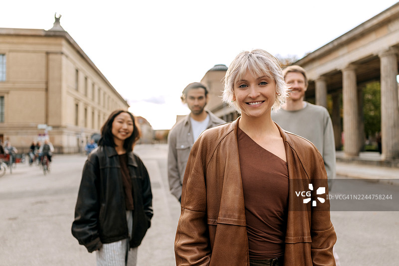 快乐的女人在户外与朋友们一起享受美好时光，面向镜头摆姿势。图片素材