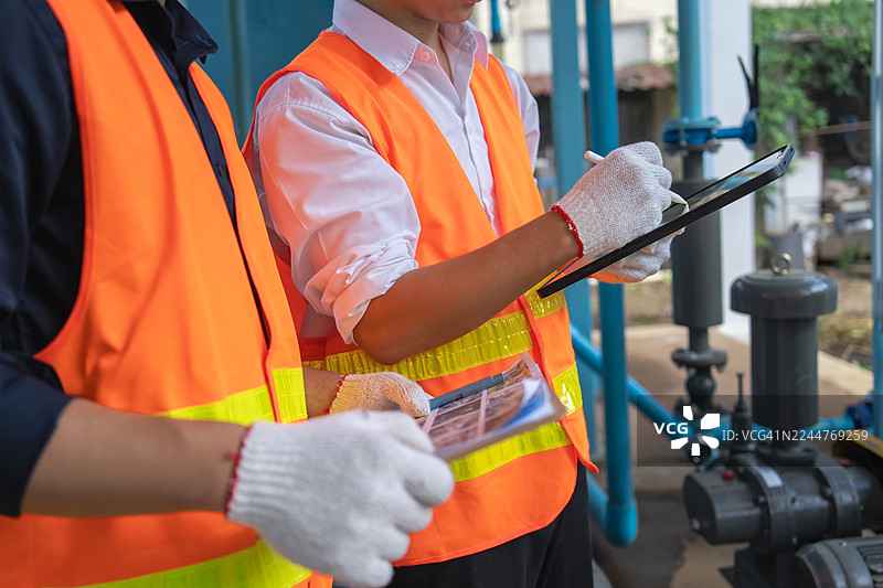 工程师和技术人员在水处理厂协作进行维护工作，确保高效运行。图片素材