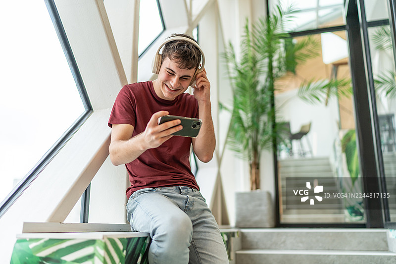 青少年享受智能手机上的音乐和视频内容图片素材