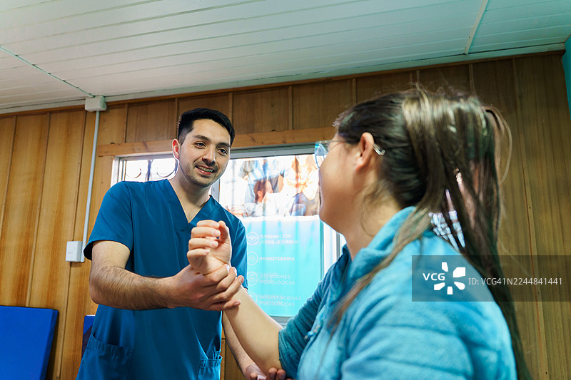 拉丁美洲的物理治疗师正在帮助患者进行手臂锻炼图片素材
