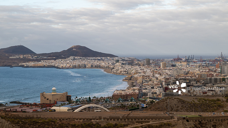 拉斯帕尔马斯-德-大加那利岛城市在多云天空下沿着拉斯坎特拉斯海滩和港口延伸图片素材