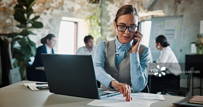 女士正在进行商务谈判，处理文件、使用笔记本电脑并接听电话，可能涉及纺织品交易的时尚预算或计划。她在共享办公空间，与客户、技术人员或供应商账户经理讨论服装材料和财务事宜，并签订合同。图片素材