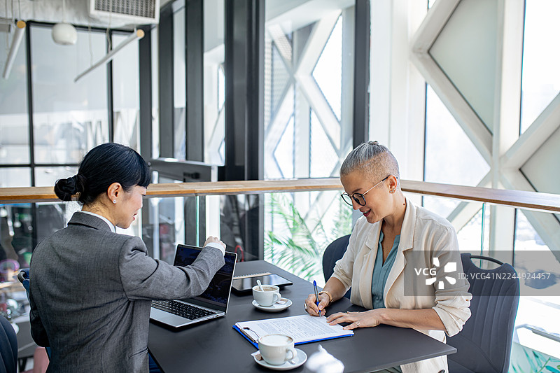 女性签署协议文件的商务会议图片素材