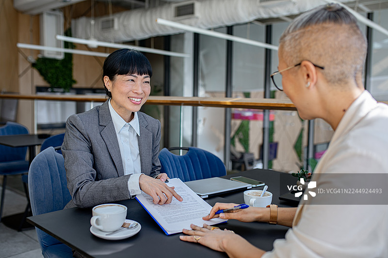 女性签署协议文件的商务会议图片素材