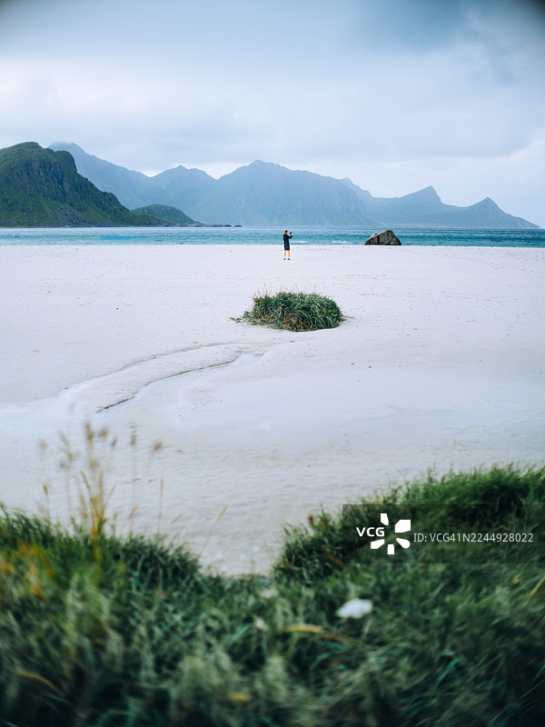 挪威罗弗敦群岛孤独旅人与风景优美的白沙滩——北极风光，包含山脉与海洋图片素材