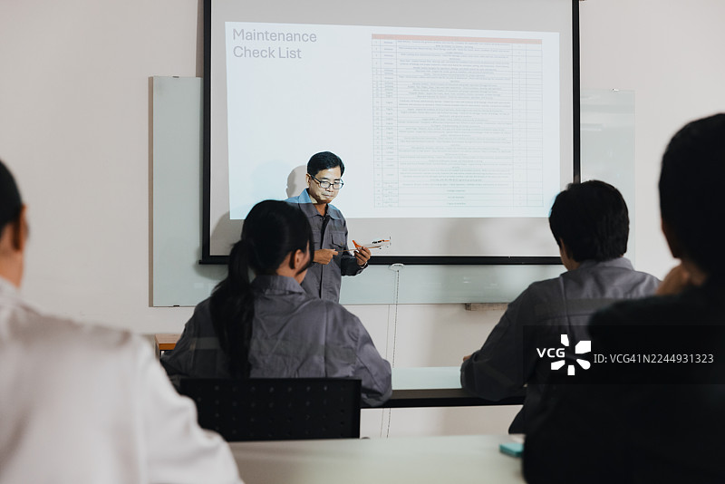 教室里的维修培训课程，一位讲师正在向一群学生授课图片素材