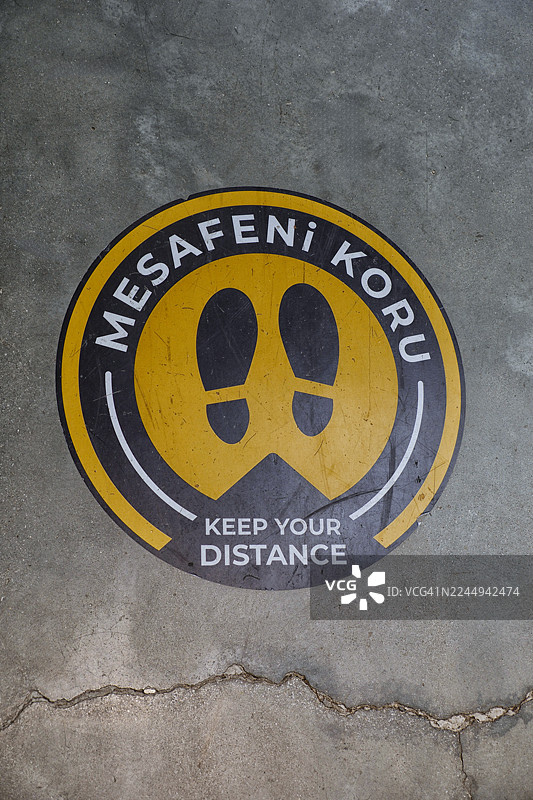 从高处俯视地面上的“请保持距离”标识。图片素材