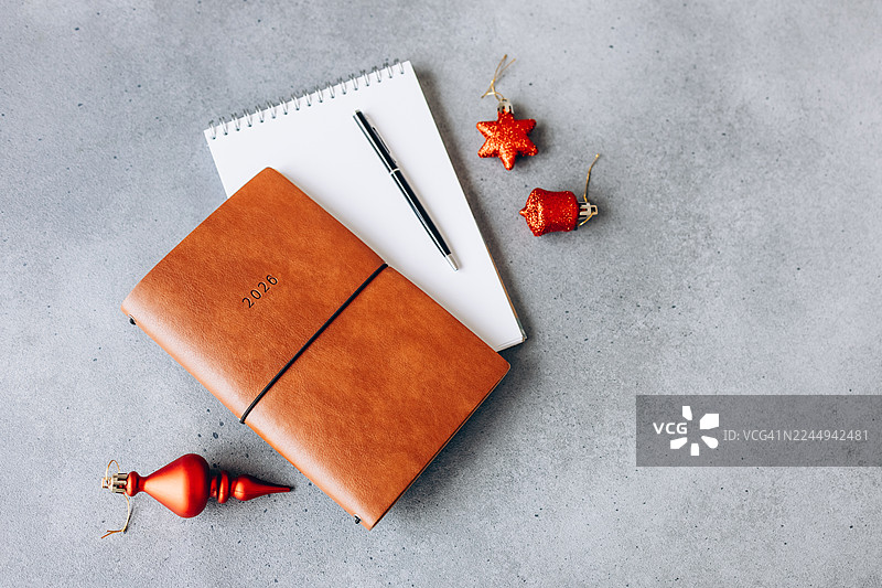 2026年规划本和笔记本，配有笔，放在灰色桌子上图片素材