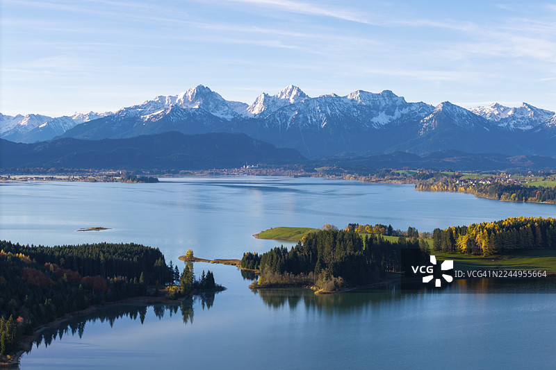 清澈的山间湖泊，岛屿上有森林，背景是山脉，伊拉斯贝格湖，福尔格湖，近罗斯豪普滕，东阿尔高，阿尔高，士瓦本，巴伐利亚，德国图片素材