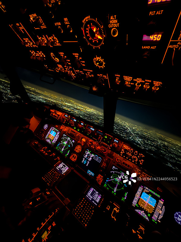 梦幻飞行——夜晚城市上空的闪耀客机驾驶舱图片素材