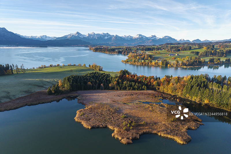 秋日湖畔风光，湖泊四周环绕着树木和山峦，位于德国巴伐利亚州施瓦本地区奥伯阿尔高县的罗斯豪普滕附近的伊拉斯贝格湖和福尔格湖。图片素材