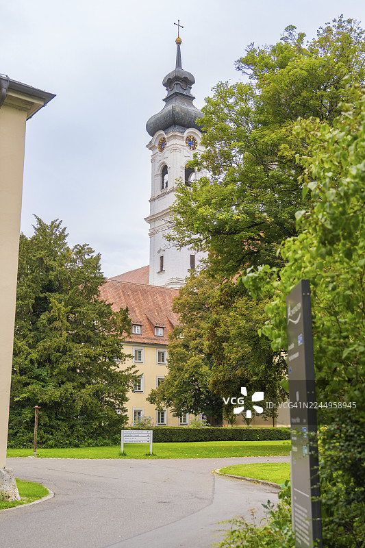 德国路特林根区茨维法尔滕的巴洛克式教堂塔楼，坐落于绿色的景观中，其后是树木和建筑群图片素材