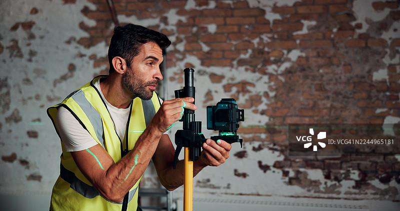 建筑、男人和激光水平仪测量墙壁，用于场地高程、平整和翻新项目。土木工程师、工人和测量设备用于结构校准和精度，并留有空间。图片素材