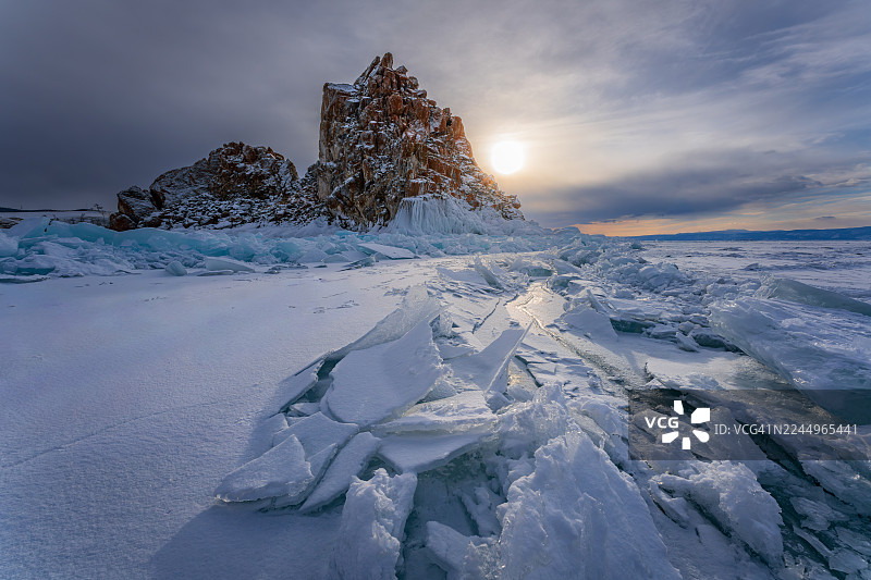 日落时分的萨满石，伴有冰裂和冰丘，贝加尔湖全景冬季景象，奥尔洪岛，西伯利亚图片素材
