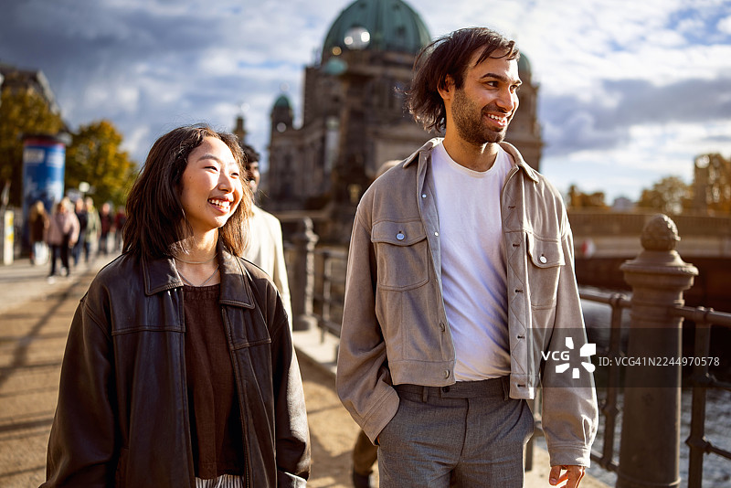 一群来自不同国家的游客在柏林大教堂附近的桥上开心地走着图片素材