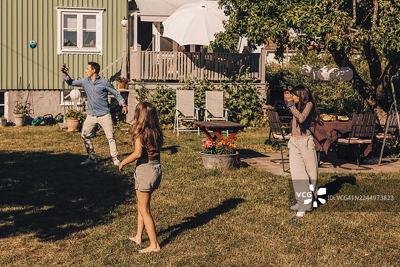 孩子们在后院与家人玩球图片素材