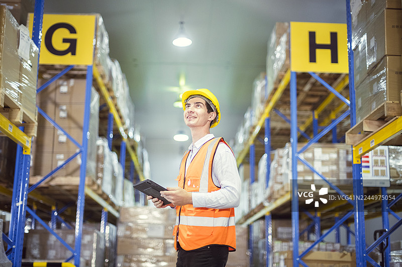 仓库工作人员使用平板电脑高效管理库存，确保现代化仓储设施的顺畅运作和优化物流。图片素材