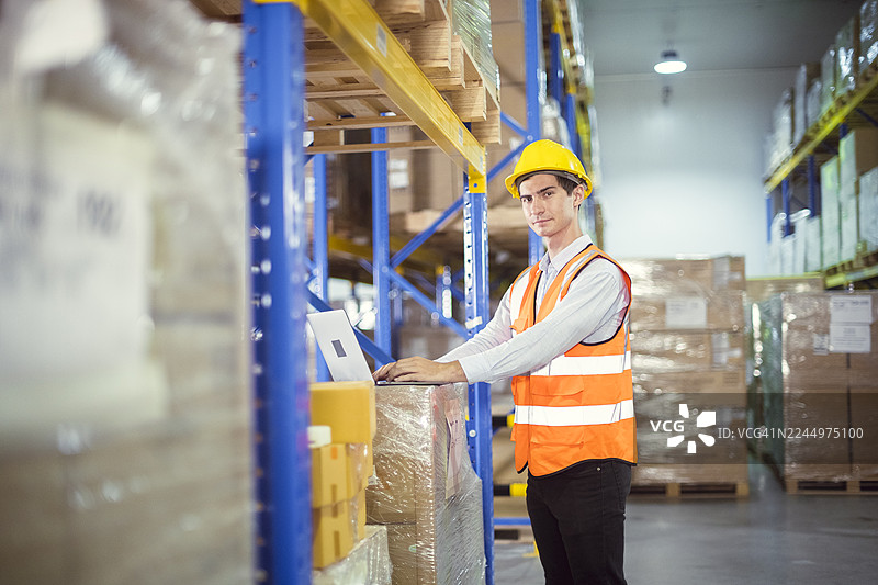 仓库工人利用科技进行库存管理。现代化设施中的高效仓储解决方案和物流运营。图片素材