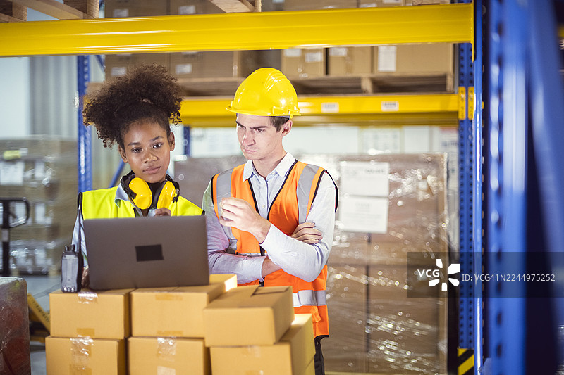 仓库团队使用笔记本电脑分析物流，提高库存管理效率。发现改进供应链绩效的精简解决方案。图片素材