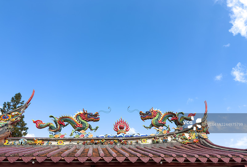 中国传统屋顶上的彩色龙雕塑图片素材