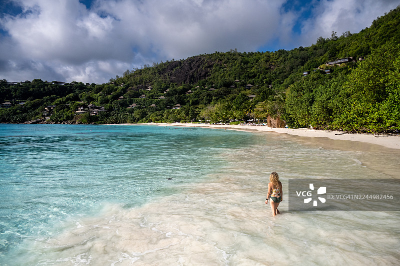 年轻女子在海滩上，中年女子在塞舌尔的热带海滩上散步。马埃岛，普蒂特安斯海滩，塞舌尔。图片素材