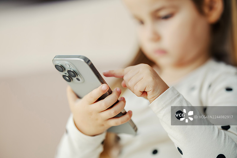 小女孩使用智能手机探索数字技术图片素材