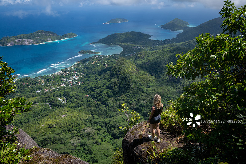 一位女性旅行者站在塞舌尔马埃岛莫恩布朗观景点悬崖上图片素材