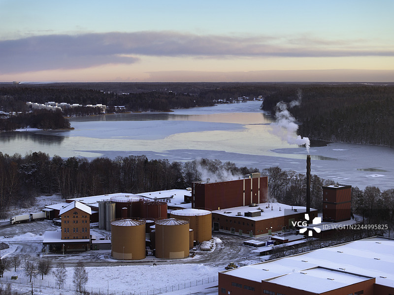 黄昏时分北欧冬季风景的鸟瞰图，其中有一个工业建筑图片素材