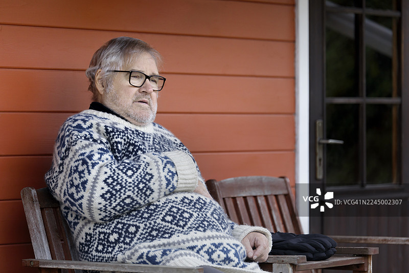 一位老年男子，头发花白，捂着胸部，显得很痛苦图片素材