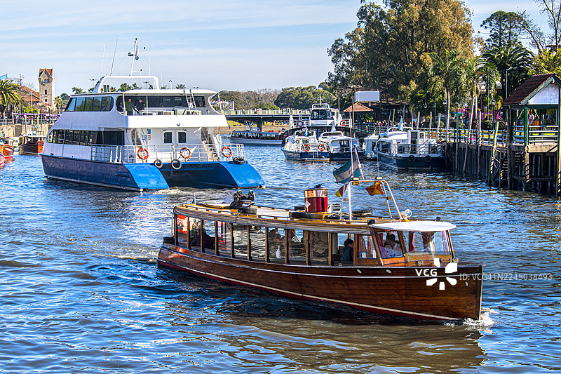 船队和双体船在河上航行。阿根廷布宜诺斯艾利斯， tigre。图片素材