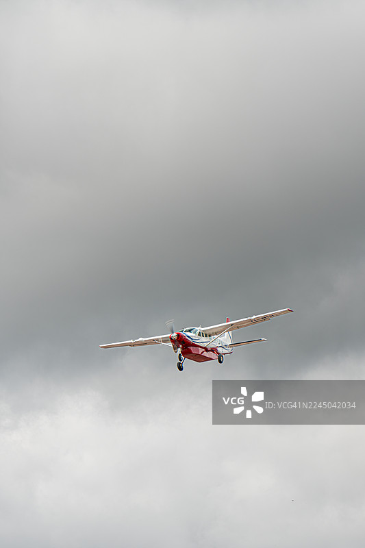 一架小型螺旋桨飞机在多云的天空中飞行图片素材