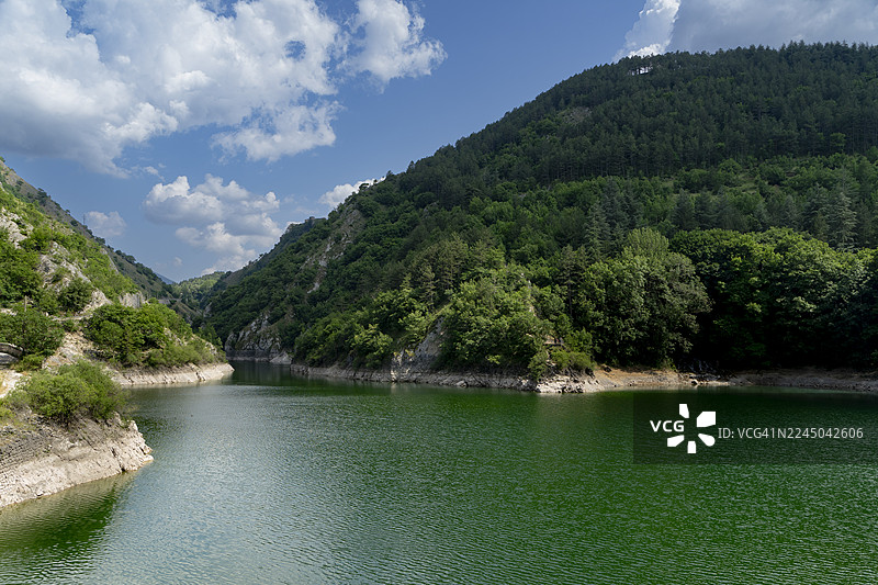 青山绿树环绕的蜿蜒河流，碧空白云下的壮丽景色图片素材