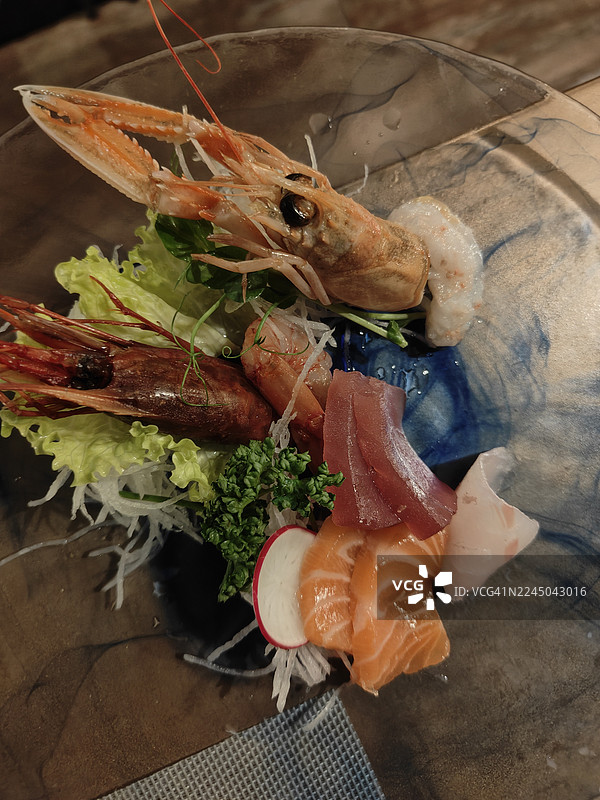 俯视视角拍摄的美味海鲜和生鱼片拼盘，盛放在装饰盘中，已准备好享用图片素材