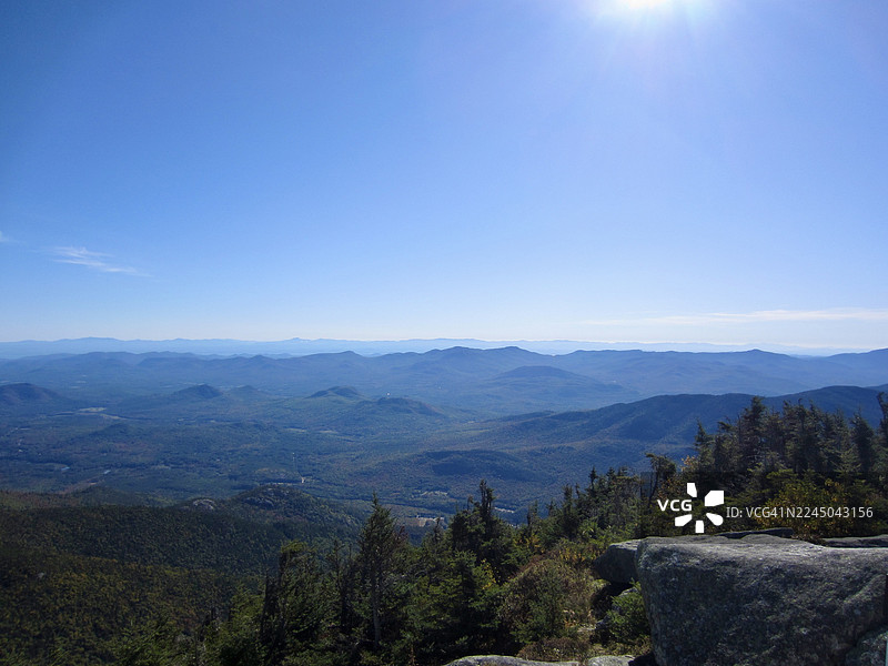 湛蓝天空下阳光明媚的山脉全景风光图片素材
