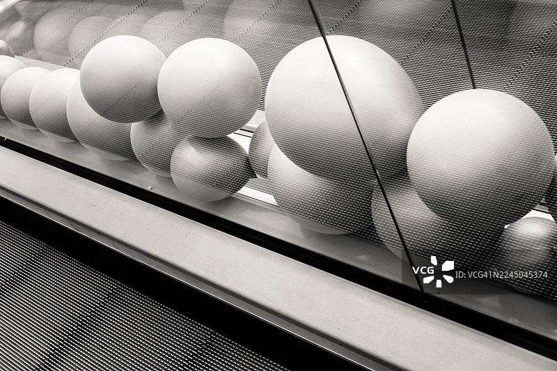 抽象的黑白图像，展示了传送带上移动的球形物体，营造出动感和工业设计的氛围图片素材
