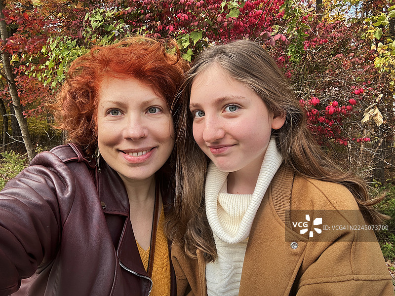 秋季在公园里，红发母女开心地自拍。新泽西的家庭亲子时光和周末活动。图片素材