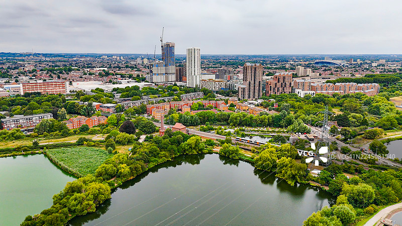 伦敦沃尔瑟姆斯托水库航拍，有货运列车和住宅区经过，工业铁路与城市水景，交通与环境保护概念图片素材