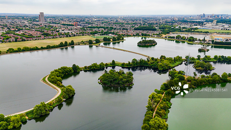 伦敦沃特福德斯托水库的鸟瞰图，周围有城市住房和绿色景观，历史悠久的维多利亚时代供水系统和自然栖息地，环境保护和城市规划概念图片素材